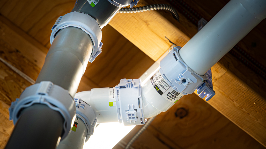 Close-up view of innoflue and innoflue lite connected beneath a wooden ceiling, illuminated by bright light.