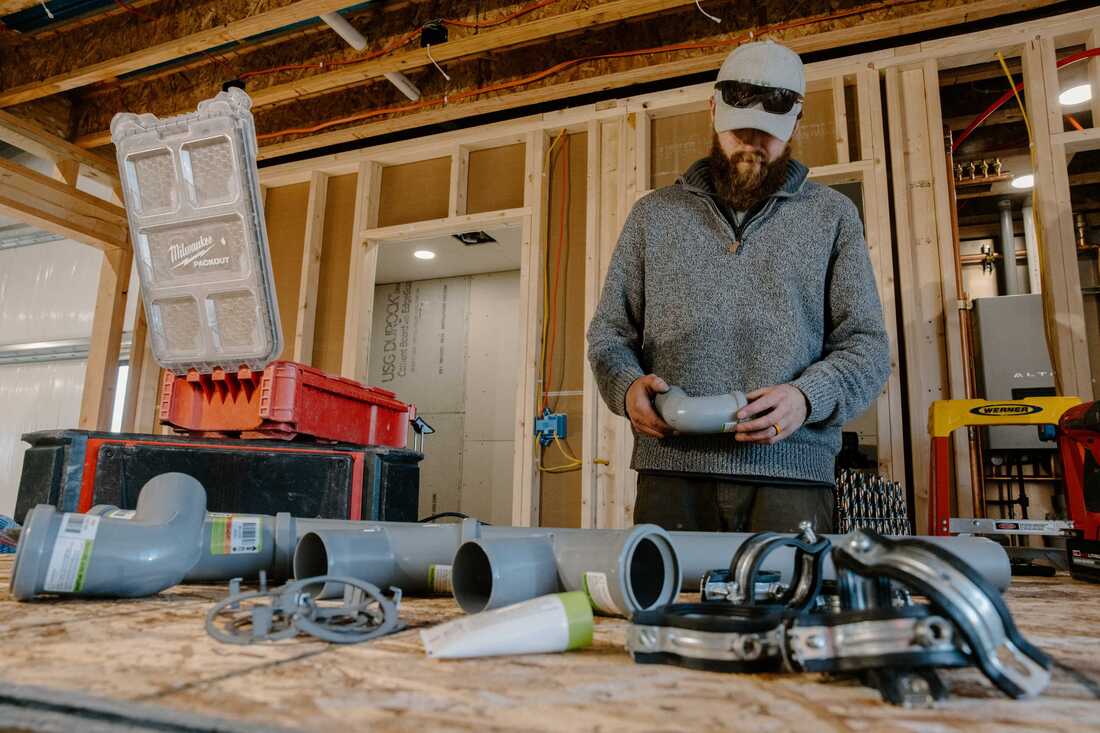 Construction worker assembling materials at an indoor job site.